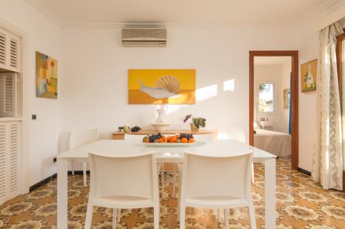 阿尔库迪亚港Villa Cactus的一间配备有白色桌椅的用餐室