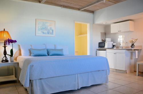 维洛海滩Sea Turtle Inn的一间蓝色卧室,配有一张床和一间厨房