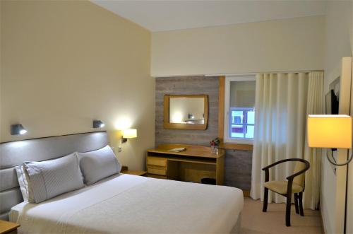 吉马良斯图罗酒店的配有一张床和一张书桌的酒店客房
