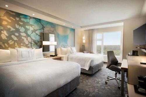 Cold LakeHotel Dene & Conference Centre的酒店客房设有两张床和窗户。