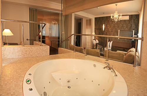 敖德萨尤利西斯酒店的带浴缸的浴室和客厅。