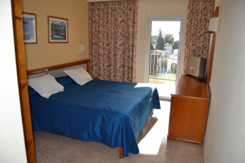 卡拉达沃利奥欧旅馆的一间卧室设有蓝色的床和窗户。