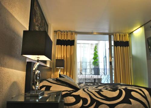 墨西哥城商务套房SG酒店的一间卧室配有一张床和一张桌子上的台灯
