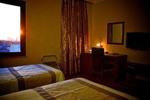 埃尔比勒埃尔比勒BL酒店的酒店客房设有两张床、一张书桌和一个窗户。