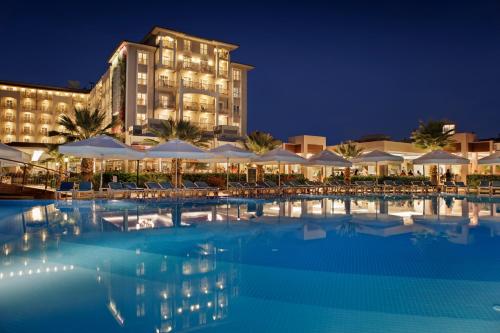 克孜拉阿奇苏尼斯艾丽塔海滩SPA度假酒店的夜间在酒店前的游泳池