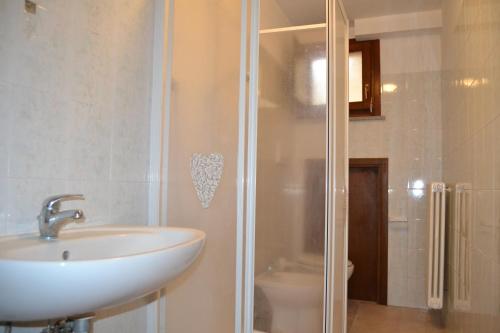 瓜尔迪斯塔洛Appartamento Belvedere的一间带水槽、淋浴和卫生间的浴室