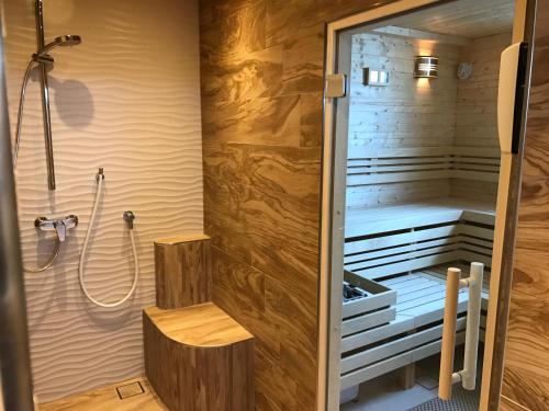 黑尔戈兰岛克拉西克公寓的一间设有淋浴的桑拿浴室和一个室内长凳