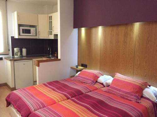 康达Alojamientos Maramar的一间卧室配有一张带条纹床单的大床