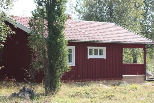 TivedGrönelid Gård的前面有一棵树的红色房子