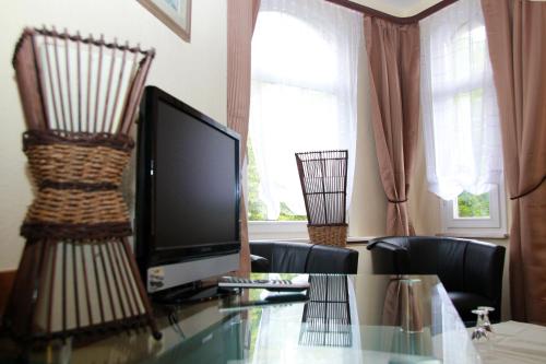 巴特萨尔奇利夫库帕克舍贝尔酒店的客厅配有玻璃桌和电视
