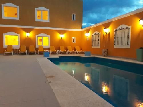 拉斯格路塔斯Hotel Colonos的一座拥有橙色墙壁的别墅内的游泳池
