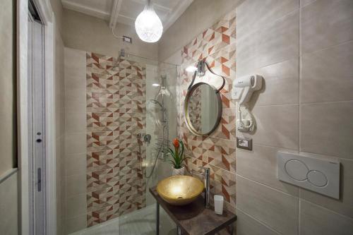 维泰博La Rocca Suite的一间带金色水槽和淋浴的浴室