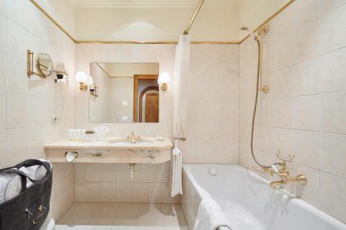 贝旺Hotel Singer – Relais & Châteaux的白色的浴室设有浴缸和水槽。