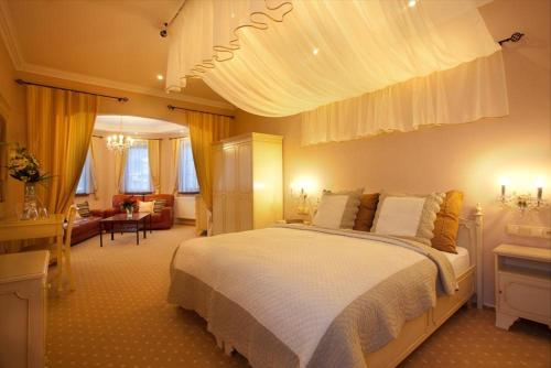 德辛Wellness Hotel Zlatá Lípa的一间带白色大床的卧室和一间客厅