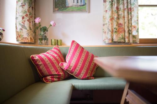 锡贝塔尔Hotel-Pension Faneskla的两个粉红色枕头坐在长凳上