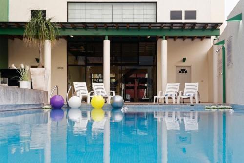 比亚埃尔莫萨Hotel Olmeca Plaza的一座建筑物边的游泳池,里面装着五颜六色的球