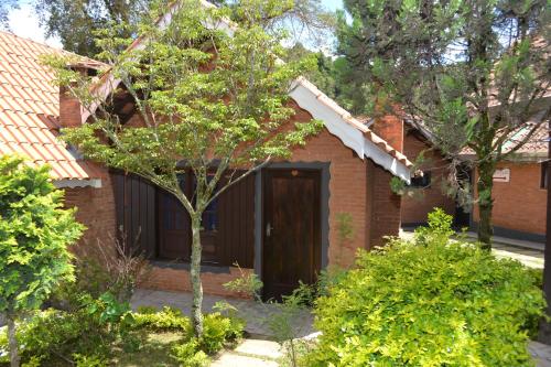 蒙特韦尔迪Pousada Sol Nascente的院子里的砖房,有棕色的门