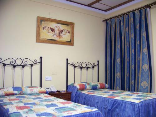 博柳略斯帕尔德尔孔达多埃尔利里奥餐厅及旅舍的配有蓝色窗帘的客房内的两张床