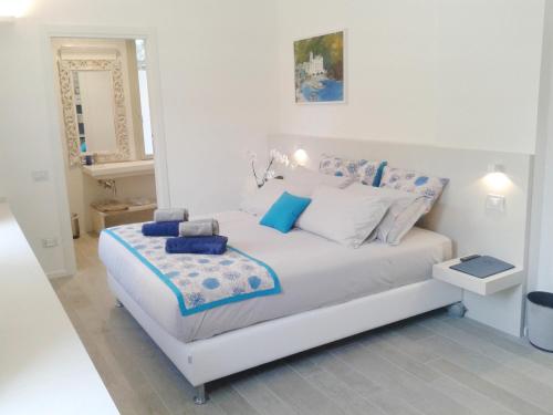里米尼玛达露酒店的白色卧室配有白色床和蓝色枕头