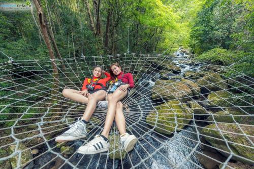 Ban Kat纳姆卡约拉霸度假村的两个女人坐在森林里的网里