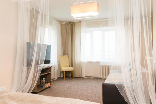 采西斯Cozy apartment in Cesis的一间卧室设有一张床、一台电视和一个窗口。