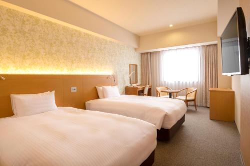 长野长野地产大酒店的酒店客房设有两张床和电视。