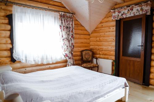 米戈韦Provintsia的小木屋内一间卧室,配有一张床和一个窗户