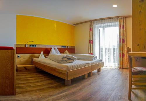 索普拉布扎诺德瑞比尔肯酒店的一间卧室设有一张床和黄色的墙壁