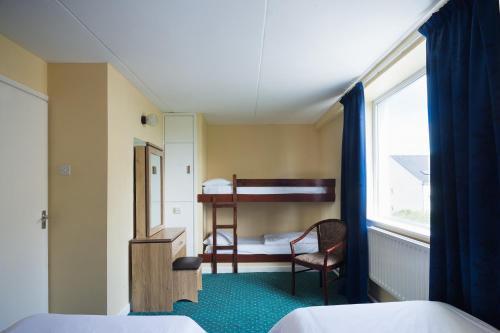 班多伦Atlantic Apartotel的小房间设有双层床和书桌