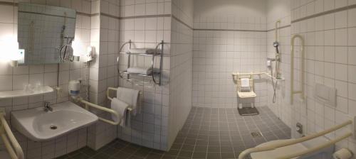 柏林希迪斯酒店的白色瓷砖浴室设有水槽和卫生间