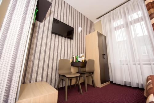 克拉科夫卡齐米2号酒店的酒店客房配有桌椅和电视。
