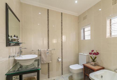 东伦敦Oceanview B&B的一间带水槽、卫生间和镜子的浴室