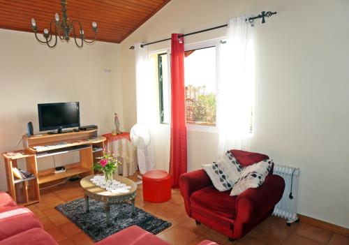 丰沙尔Villa Catanho的客厅配有红色椅子和电视