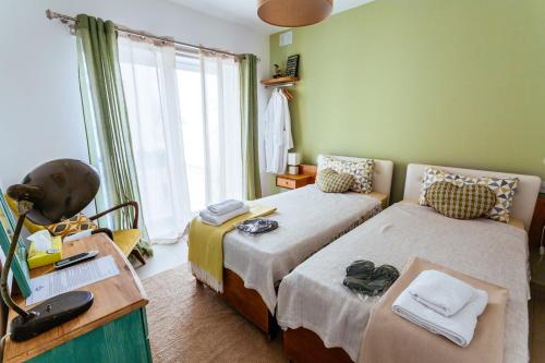 梅利哈Ghand in-Nanna B&B的一间卧室设有两张床、一张桌子和一个窗口。