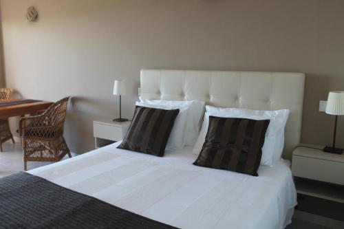拉戈斯维温达索尔玛酒店的卧室配有白色的床和2个枕头