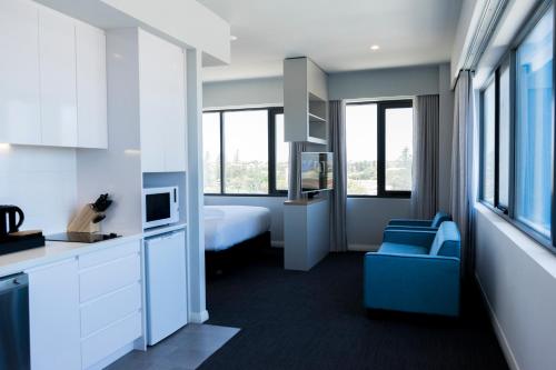 杰拉尔顿杰拉尔德公寓式酒店的酒店客房,配有一张床和一张蓝色椅子
