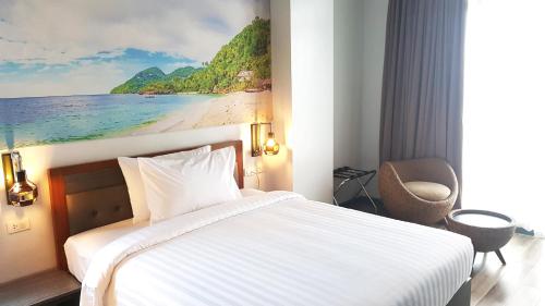 卡利博GQ Plaza的酒店客房,配有一张床和海滩画