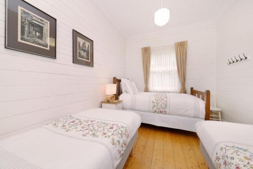 温特沃斯瀑布Poet's Cottage - Fireplace, Close to Treks的一间卧室设有两张床和窗户。