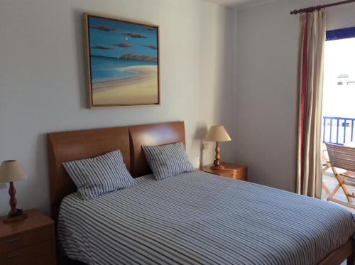 普拉亚布兰卡Villa Anclazul Marina Rubicon的一间卧室配有一张带蓝色和白色条纹棉被的床