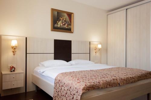 喀山MiniHotel Prazhsky Klub的卧室配有一张大床,墙上挂着一张照片