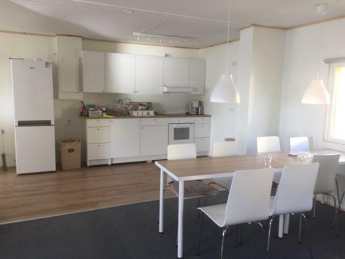 Sandavágur吉莲内斯旅舍的厨房配有白色橱柜和桌椅