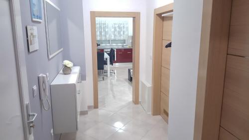 奥西耶克Apartman Pampas Osijek的通往厨房的走廊,厨房铺有白色地板