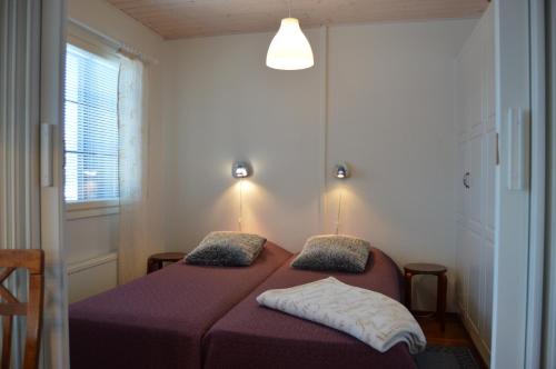 塔库沃里Pointin Vale Apartment Tahko的一间卧室配有一张带紫色床单的床和窗户。