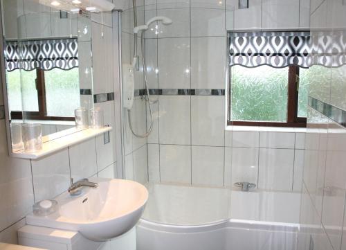 UldaleEmerald Bank Cottage的白色的浴室设有水槽和浴缸。