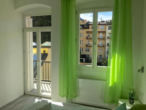 博尔扎诺Iceman Room's Central的配有绿色窗帘的客房,享有建筑的景致