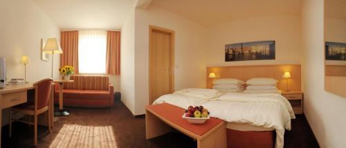 维斯马Lübsche Thorweide的配有一张床和一张书桌的酒店客房