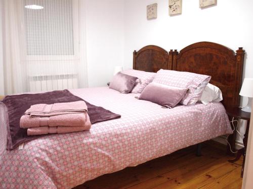 莱昂Piso Madrazo的一张带粉红色毯子和枕头的床