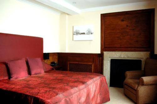 爱恩赫卡特赖特酒店的一间卧室配有红色的床和椅子