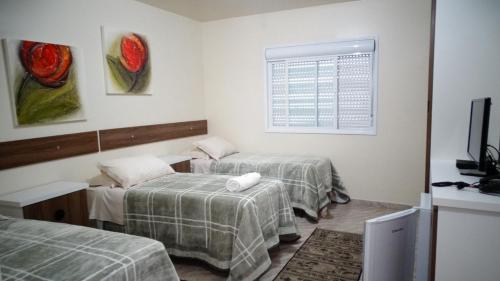 MontenegroHotel Niro的客房设有两张床、一台电视和一扇窗户。