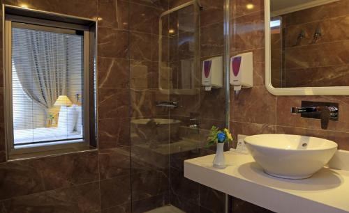 居吕克Roseira Beach Resort的一间带水槽和玻璃淋浴的浴室